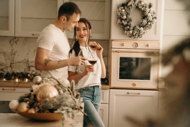 Kot pantolon ve tişört giyen üç kişilik bir aile yeni yıl mekanlarında poz veriyor.