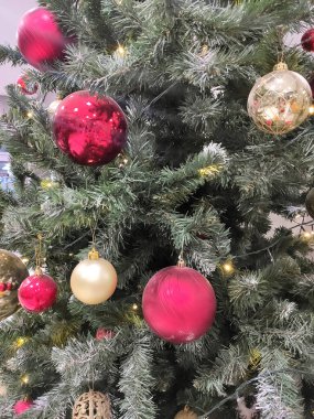 Altın ve kırmızı topları olan bir Noel ağacı. Oyuncak dolu Noel dalları.