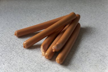 Bir sürü sosis beyaz, siyah noktalı bir masada yatıyor.