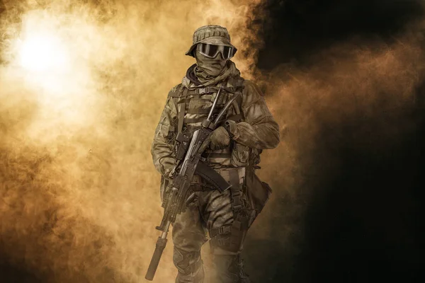 Special Forces soldier. Special Operations fighter with AK-74 assault rifle holding a machine gun on smoke background