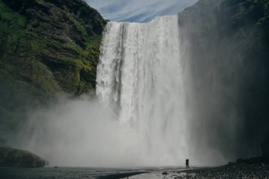 Güney İzlanda 'daki Skogarfoss şelalesinde turistler var. Yüksek kalite fotoğraf