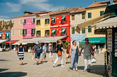 BURANO, İtalya - nov, 2021 Burano adası. Çok güzel renkli evleri ve köyü ziyaret eden bir grup turisti var. Yüksek kalite fotoğraf