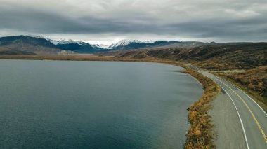 Alaska 'daki Kenai Yarımadası' nda sakin bir göl ve görkemli dağ zirveleri üzerinde dramatik ve karamsar bir gökyüzü. Yüksek kalite fotoğraf