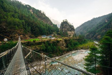 Nepal 'deki Annapurna gezisinde Budist dua bayraklarıyla asma köprü. Yüksek kalite fotoğraf