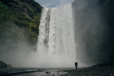 Güney İzlanda 'daki Skogarfoss şelalesinde turistler var. Yüksek kalite fotoğraf