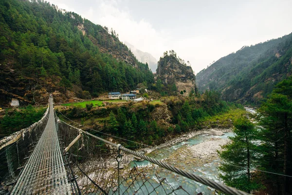 Nepal 'deki Annapurna gezisinde Budist dua bayraklarıyla asma köprü. Yüksek kalite fotoğraf