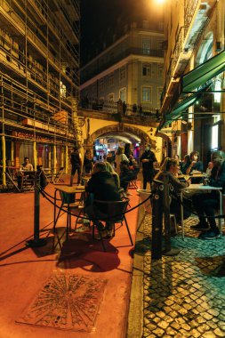 Lisbon, Portugal - Sep 2021: View of the pink street in Lisbon, with tourists, businesses, bars and colorful umbrellas on top. High quality photo