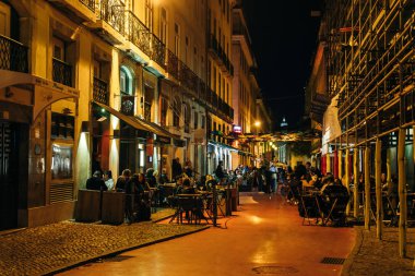 Lisbon, Portugal - Sep 2021: View of the pink street in Lisbon, with tourists, businesses, bars and colorful umbrellas on top. High quality photo