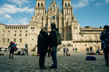 Backpackers and pilgrims looking at Santiago de Compostela Cathedral standing on the Obradeiro square. High quality photo
