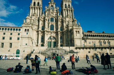 Backpackers and pilgrims looking at Santiago de Compostela Cathedral standing on the Obradeiro square. High quality photo