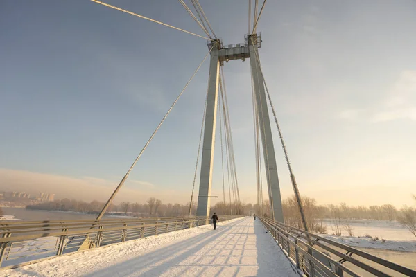 snow-covered bridge over the river in the winter in the sunrise Russia, Krasnoyarsk Vinogradovsky Bridge or Vantovy Bridge. High quality photo