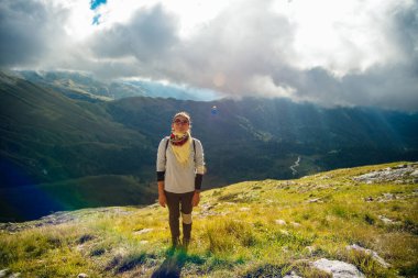 Yüksek dağlardaki kayalıklarda yürüyüş yapan turist kız ve vadinin muhteşem manzarasının tadını çıkarıyor. Yüksek kalite fotoğraf