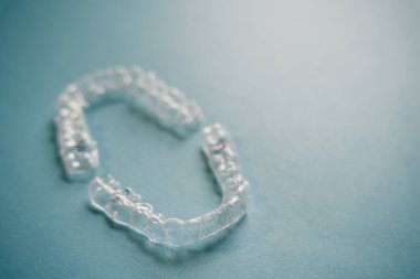 Diş tellerini ya da mavi arkaplandaki görünmez diş tellerini inceleyin. Yüksek kalite fotoğraf