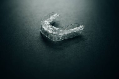 Diş tellerini ya da siyah arkaplandaki görünmez diş tellerini inceleyin. Yüksek kalite fotoğraf