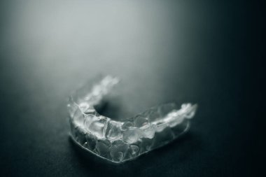 Diş tellerini ya da siyah arkaplandaki görünmez diş tellerini inceleyin. Yüksek kalite fotoğraf