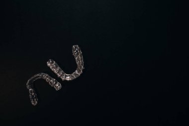 Diş tellerini ya da siyah arkaplandaki görünmez diş tellerini inceleyin. Yüksek kalite fotoğraf