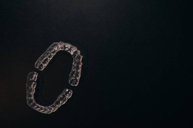 Diş tellerini ya da siyah arkaplandaki görünmez diş tellerini inceleyin. Yüksek kalite fotoğraf