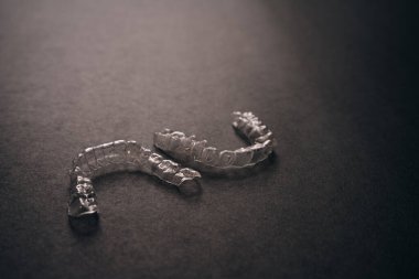 Diş tellerini ya da siyah arkaplandaki görünmez diş tellerini inceleyin. Yüksek kalite fotoğraf