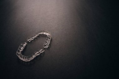 Diş tellerini ya da siyah arkaplandaki görünmez diş tellerini inceleyin. Yüksek kalite fotoğraf