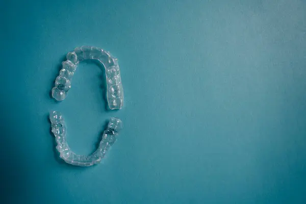 Invisalign braces or invisible retainer on blue background. High quality photo
