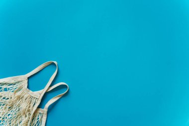 Mavi arka planda alışveriş yapmak için boş bir hasır çanta. Yüksek kalite fotoğraf