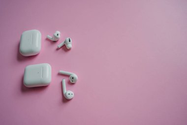 White headphones with wireless charging case. New Airpods 2019-2020 on black background. Female and male headphones. Copy Space. Phone. canada - may, 2022 clipart