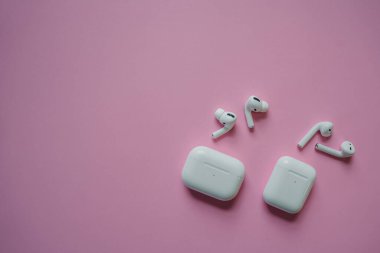 White headphones with wireless charging case. New Airpods 2019-2020 on black background. Female and male headphones. Copy Space. Phone. canada - may, 2022 clipart