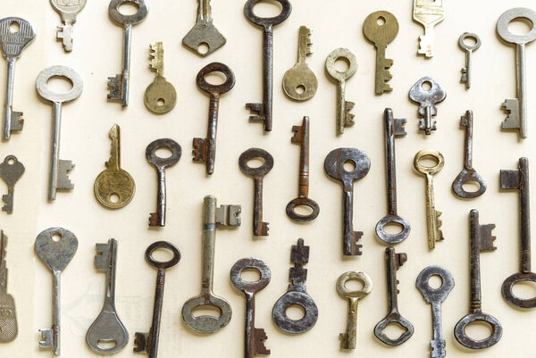 Antique keys are commonly reffered to as a bit or barrel keys, the former having a solid shrank and the latter being hollow. Here are some old antique and vintage keys against paper background.