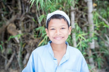 Müslüman çocuklar bambu ormanında gülümsüyor.