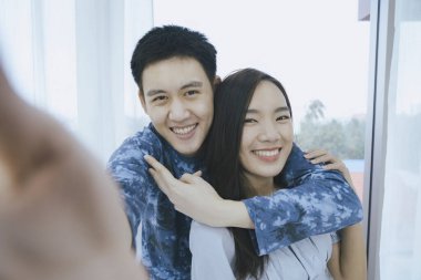 Bir turist çift otel odalarında selfie çekmek için cep telefonu kullanıyor.. 