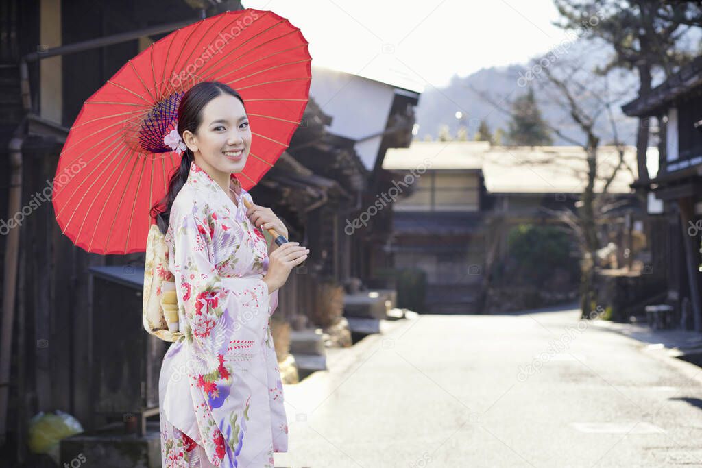 Asian woman tourists. Beautiful girl wearing traditional japanese kimono in popular in Old village at Nagano Prefecture, Japan.