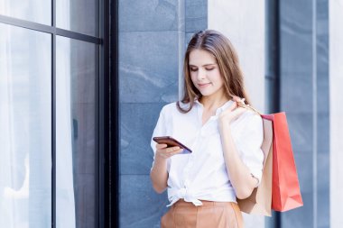 Beautiful woman enjoy with paper shopping bag on the city.