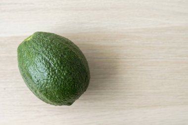 Ahşap zeminde yeşil avokado. Tahta masada taze avokado..