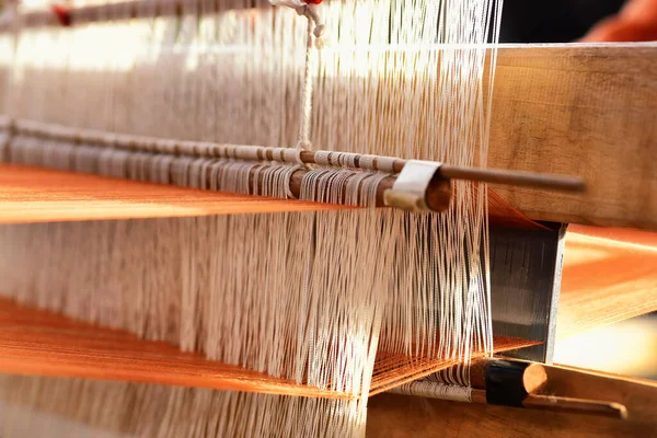 Traditional Isan Thai cotton weaving. The weaving cotton in traditional way at manual loom. Buriram, Thailand.