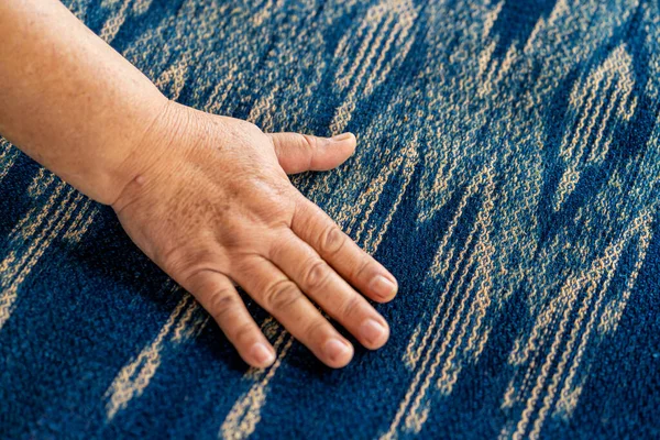 Yaşlı bir kadın pamuktan yapılmış ipliği inceliyor. Yerel usta Sakon Nakhon bölgesinin orjinal Indigo Cotton Weaver 'ıdır..