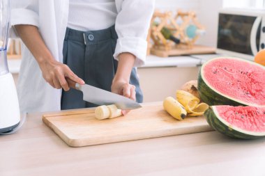 Sağlıklı yaşam ve vejetaryen yemekleri. Vejetaryen yemeği pişirmek. Şef salata süslemek için muz kesiyor..