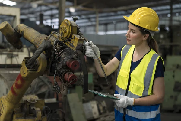 年轻妇女在工业工厂工作 工头拿着夹板 看看机器是如何工作的 — 图库照片