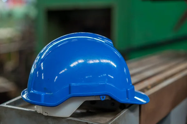 Hard hat blue. Blue construction hat in factory.
