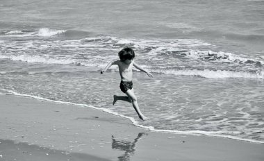 Akdeniz 'in, Katalonya' nın, İspanya 'nın en harika yerlerinden biri olan Ebro Delta nehrinin Fangar sahilinde koşan ve eğlenen küçük sevimli çocuk..