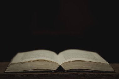 Antik ahşap masada, aydınlık tarzlı karanlık bir odada, incili aç.