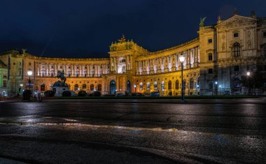 Viyana, Avusturya - 06 Ekim 2021: Viyana 'daki Hapsburg İmparatorluk Sarayı' nın görkemli cephesi. Barok binası, gece lambasıyla aydınlatılmış.