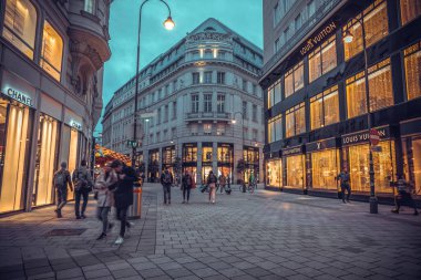 Viyana, Avusturya - 07 Ekim 2021: Viyana 'nın tarihi çeyreğinde sokak lambalarıyla aydınlatılan sokak lambaları ve lüks mağazalar, aksesuarlar ve butikler.