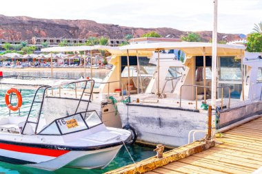 Sharm El Sheikh, Mısır - 30 Kasım 2021: Mısır 'da Sharm El Sheikh limanına demirlemiş eğlence turisti ve devriye botları. Kızıl Deniz 'in parlak masmavi suyu ve turist plajı.