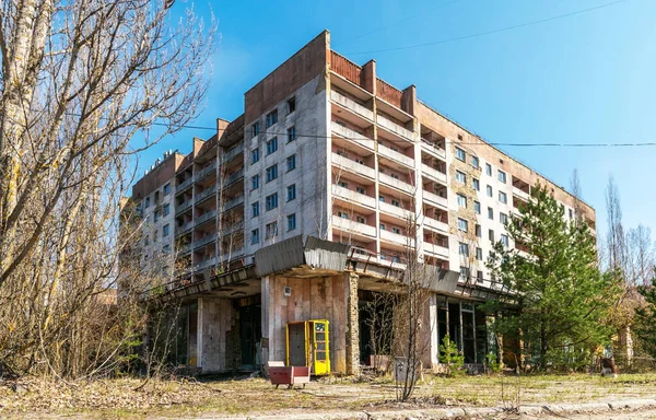 Pripyat 'ın terk edilmiş hayalet kasabasının sokağı. Çernobil nükleer felaketinin yasak bölgesindeki ağaçlar ve yıkılan evler.