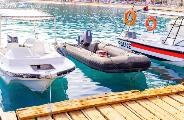 Sharm El Sheikh, Mısır - 30 Kasım 2021: Mısır 'da Sharm El Sheikh limanına demirlemiş eğlence turisti ve devriye botları. Kızıl Deniz 'in parlak masmavi suyu ve turist plajı.