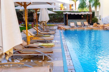 Sharm el Sheikh, Mısır - 03 Aralık 2019: Sharm El Sheikh, Sina Yarımadası, Mısır 'da lüks bir tropikal tatil beldesinde temiz bir yüzme havuzu ve güverte sandalyeleri