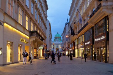 Viyana, Avusturya - 07 Ekim 2021: Viyana 'nın tarihi çeyreğinde sokak lambalarıyla aydınlatılan sokak lambaları ve lüks mağazalar, aksesuarlar ve butikler.