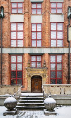 Gdansk, Polonya - 23 Ocak 2022: Gdansk Polonya 'nın tarihi bölgesinde eski bir lüks evin ahşap kapılı ve dekore edilmiş cephesi. Ortaçağ gotik mimarisi. Orta Avrupa 'ya turizm gezisi