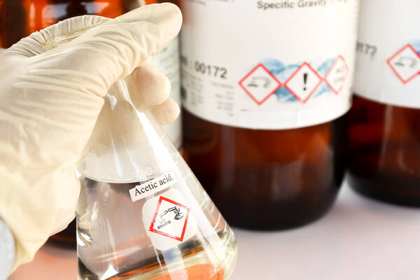 Acetic acid in glass, chemical in the laboratory and industry