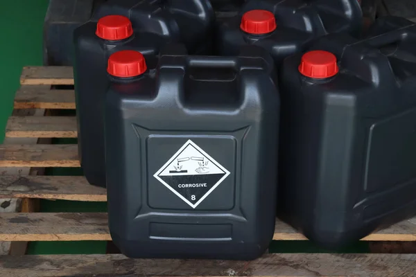 Corrosive chemical symbols on a black chemical tank